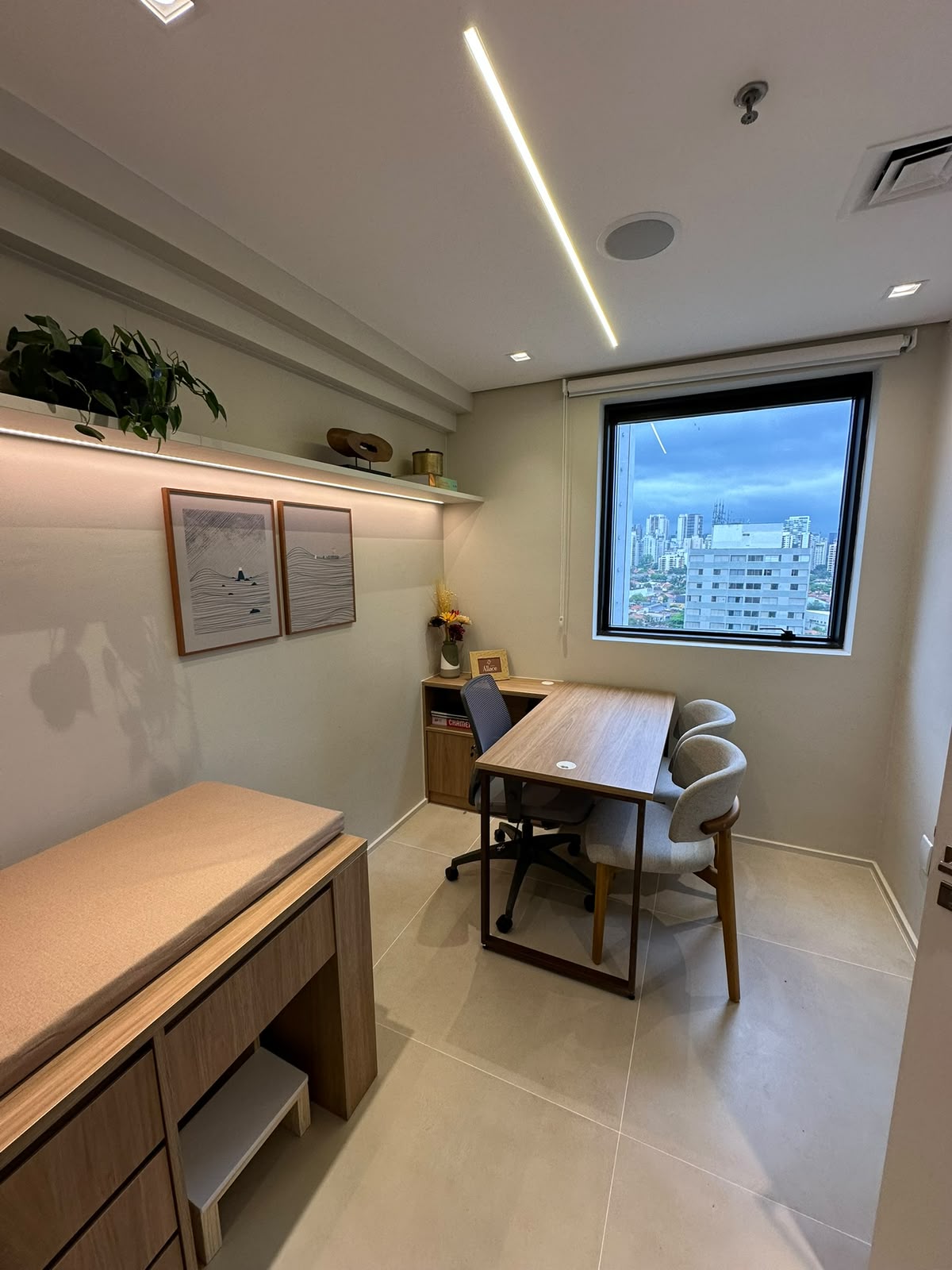 Consultório com mesa, cadeiras e janela com vista para a cidade